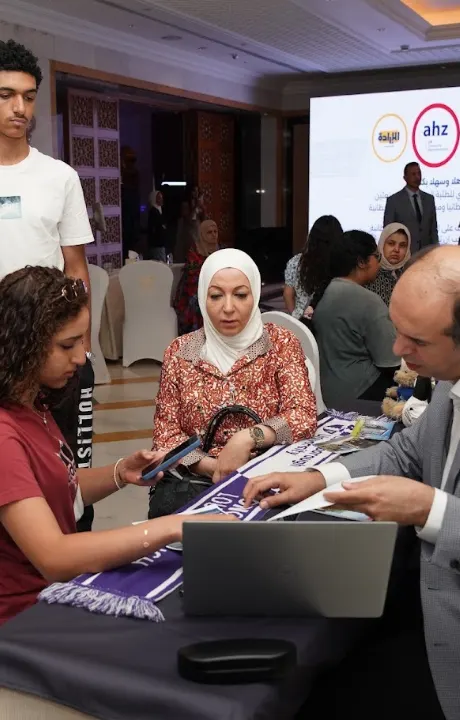 An AHZ adviser helping a student and her family at a university fair